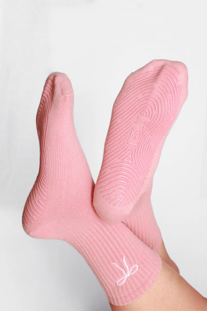 Pink socks with a white logo on a light gray background