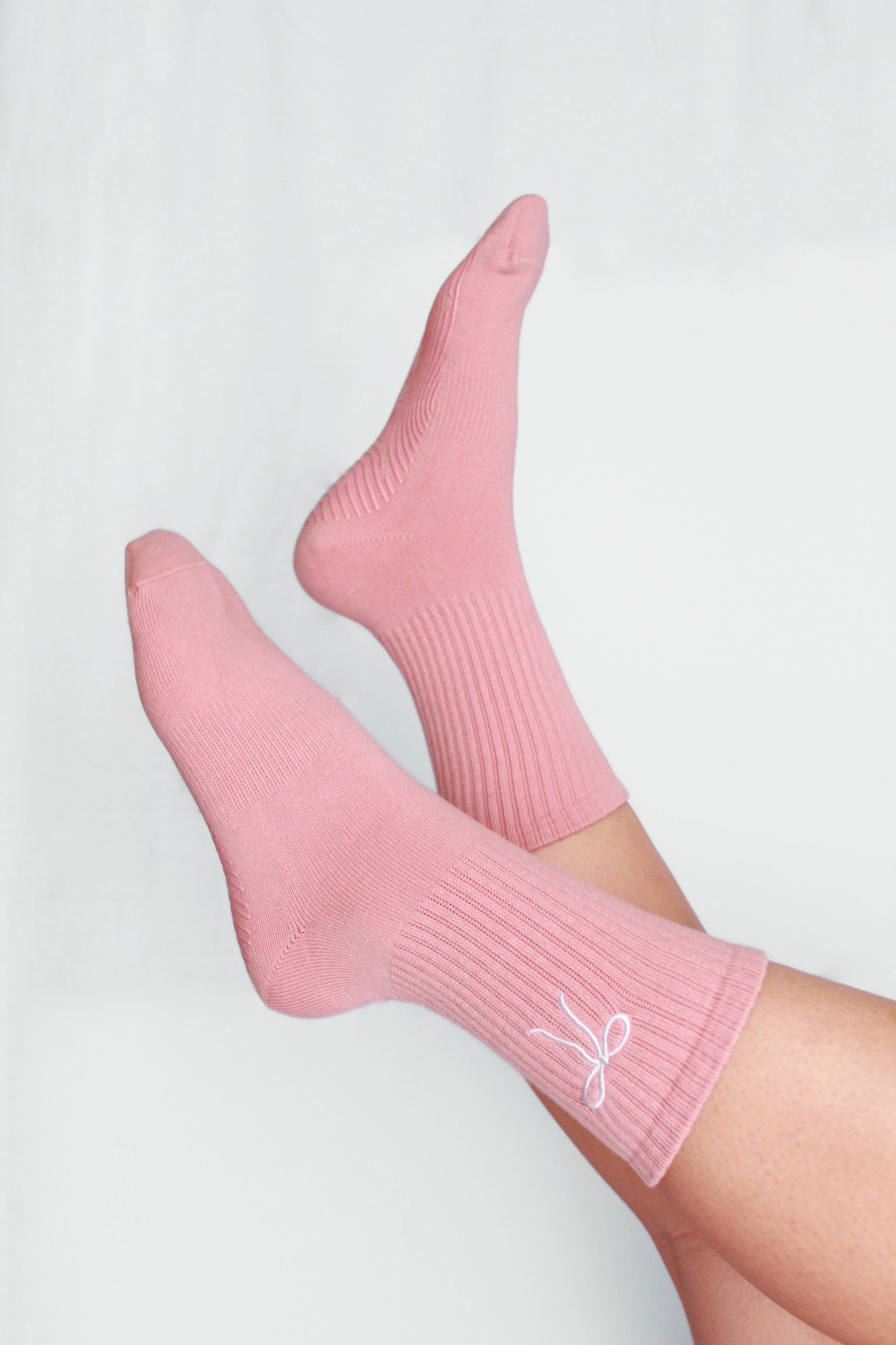 Pink socks with a logo on a light gray background