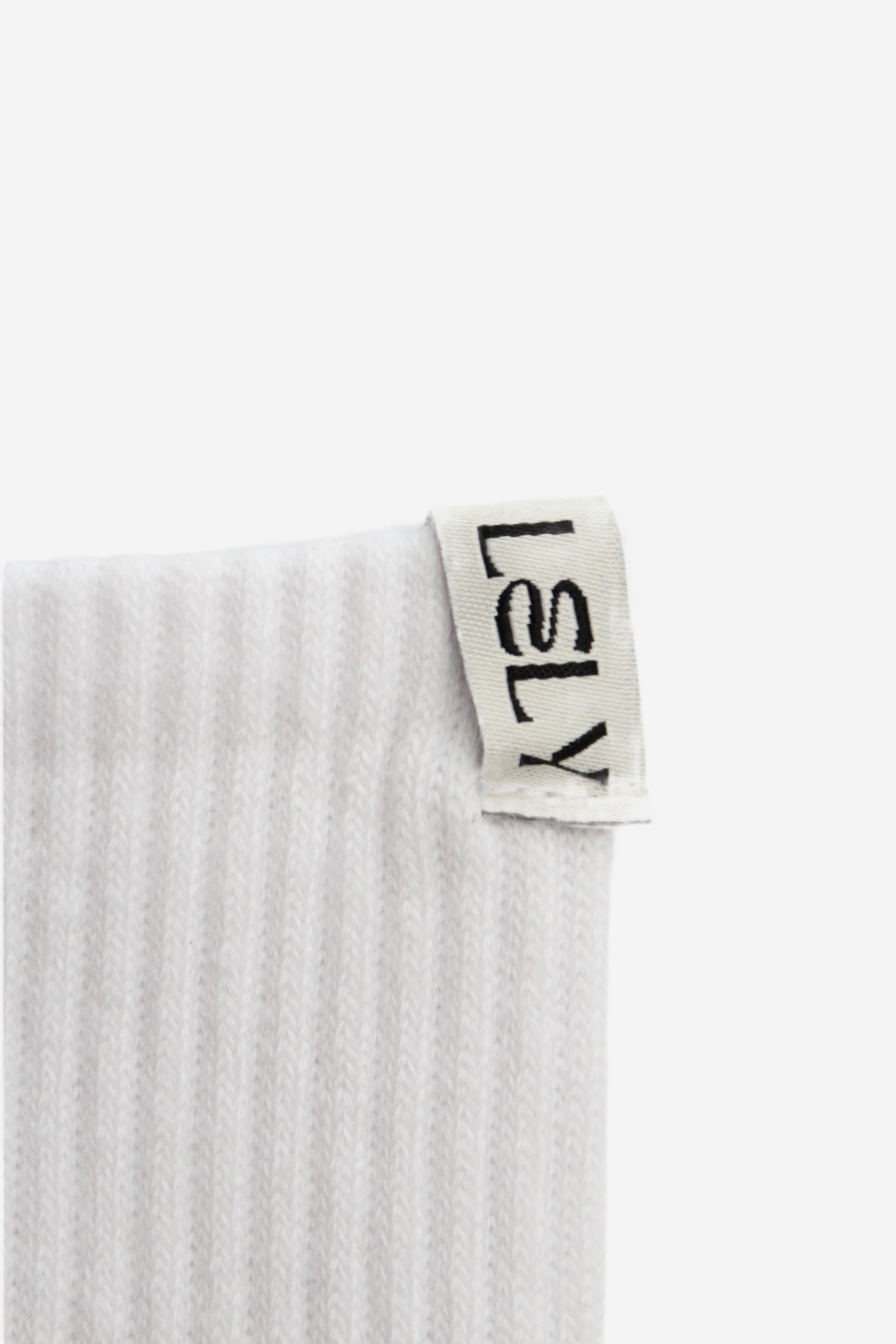 Close up of sock with a 'LELY' woven label on a white background