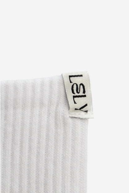 Close up of sock with a 'LELY' woven label on a white background