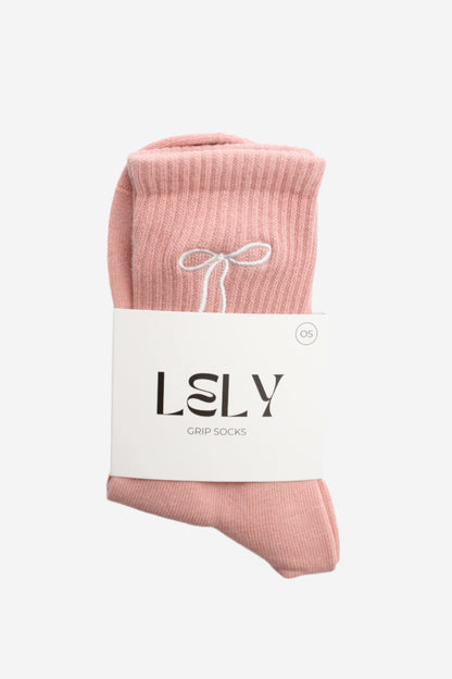 Pink socks with a white bow on a white background, featuring the brand 'LELY'.