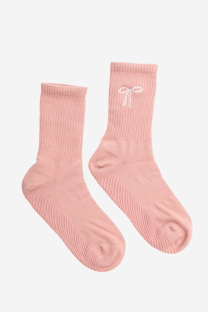 Pair of pink socks with a white bow design
