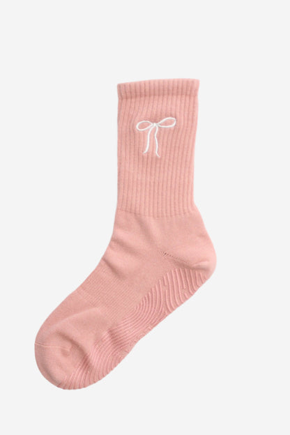 Pink sock with a white bow design